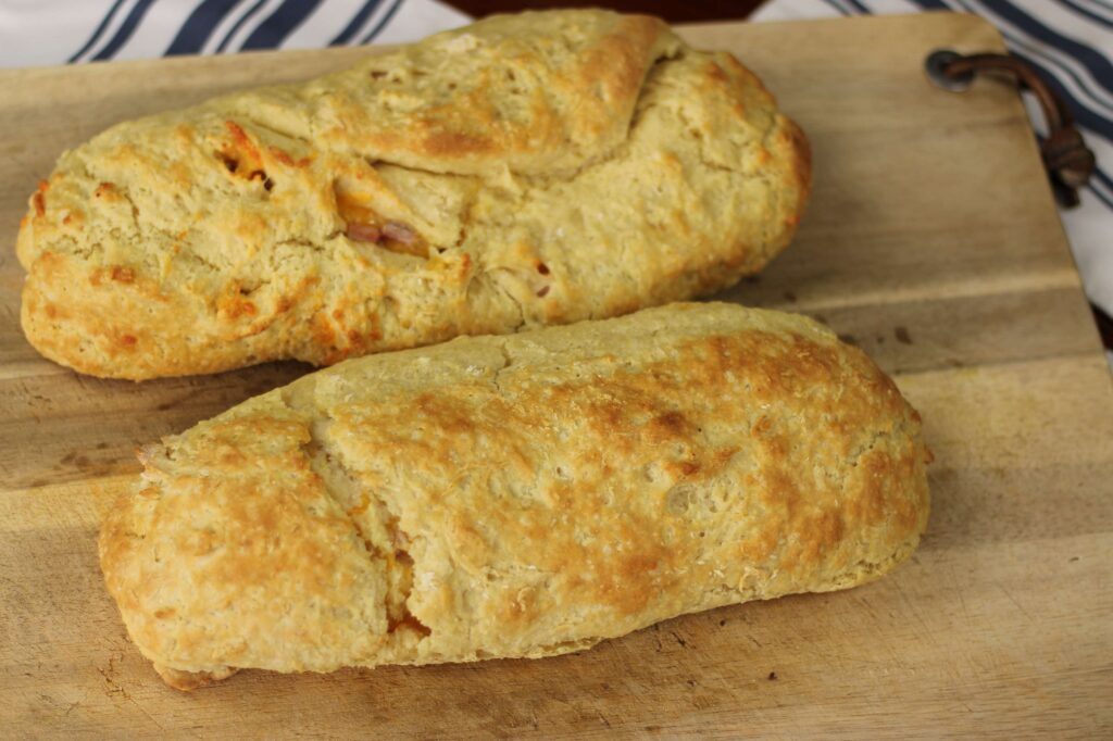 Two bread loaves on a wooden cutting board