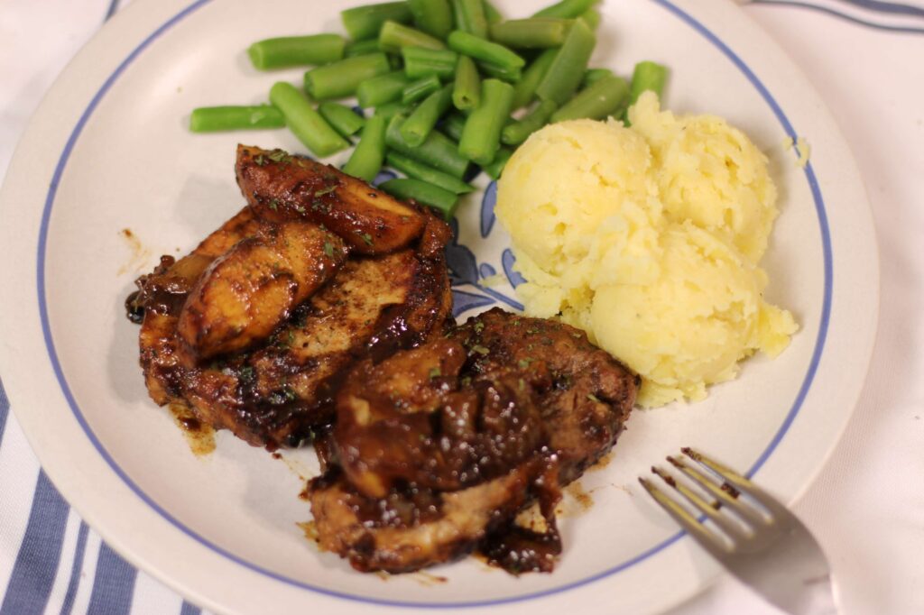 caramel apple porkchops, mash potatoes and green beans on a plate