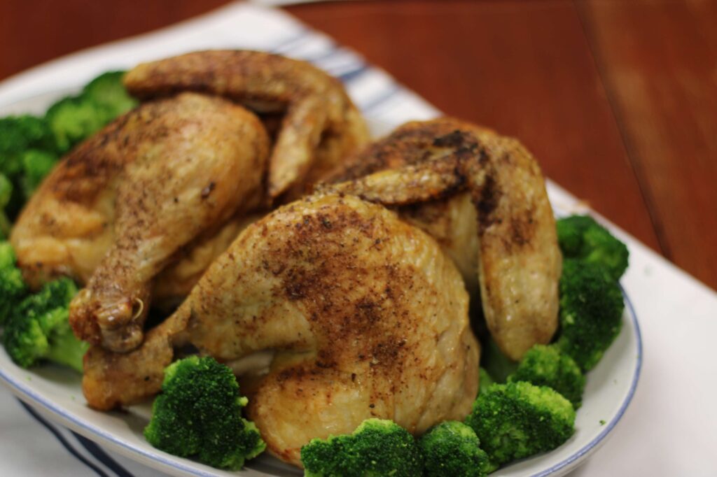 air fried roasted chickens on a platter with broccoli