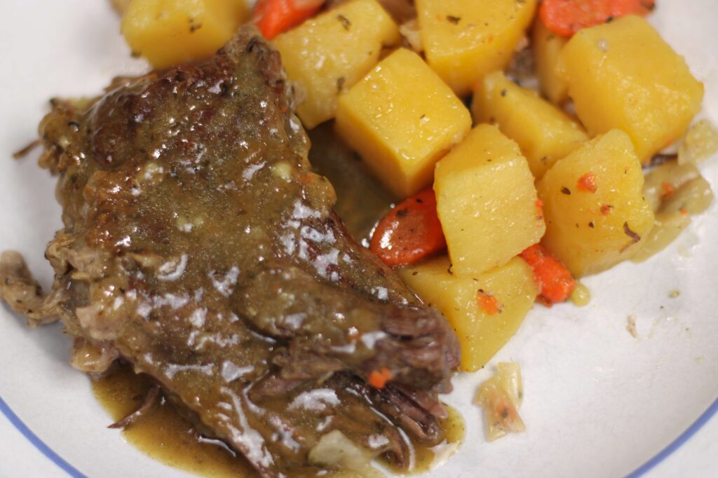 dutch oven cooked pot roast and vegetables on plate