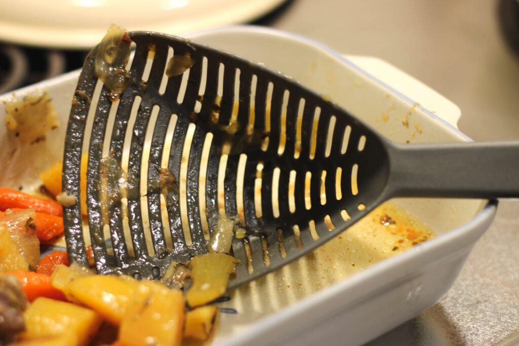 gray scoop colander removing vegetables from pot