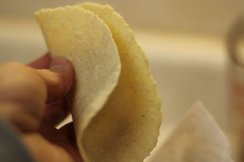 hand holding homemade corn tortilla