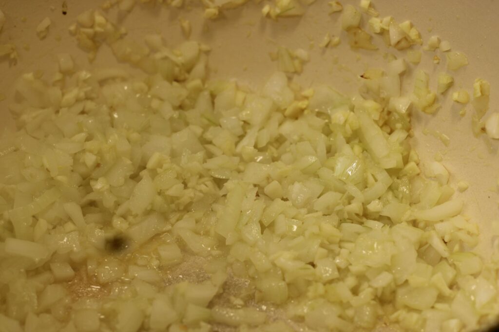 process shot of minced onions and garlic cooking for homemade marinara sauce