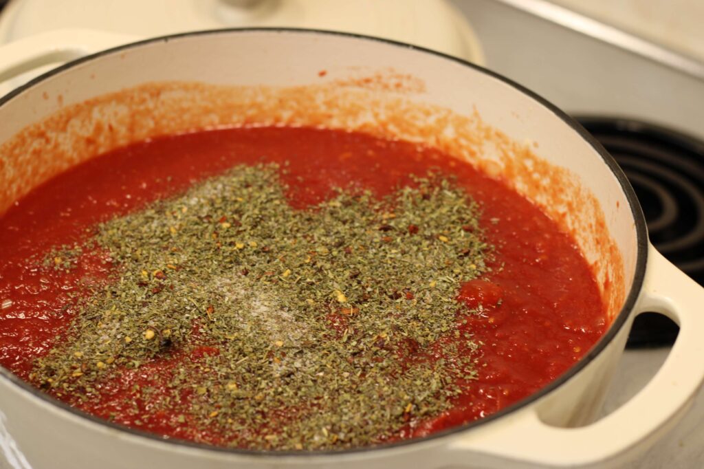 process picture of marinara sauce cooking showing herbs and spices 