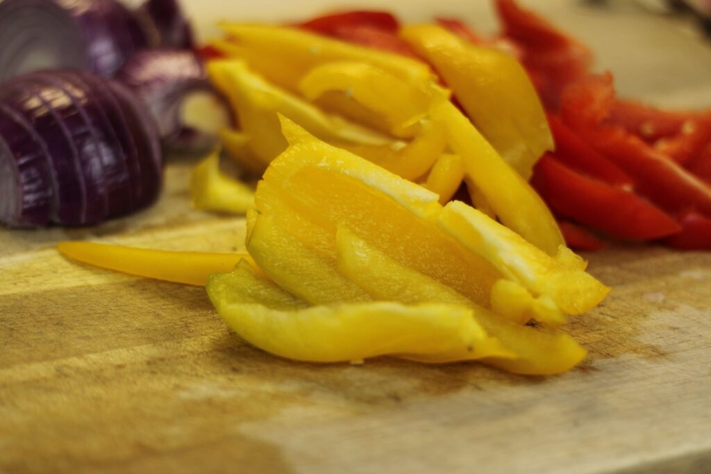 sliced yellow and red bell peppers and red onions