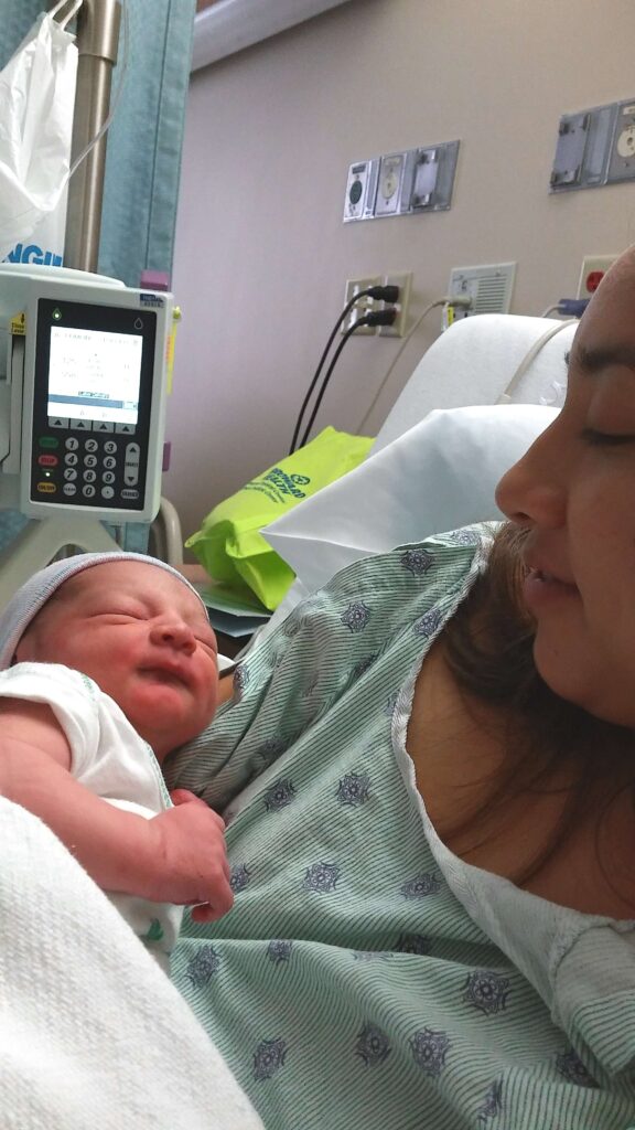 women holding newborn in hospital bed 