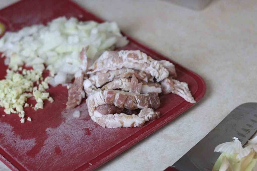 cut up bacon on red cutting board