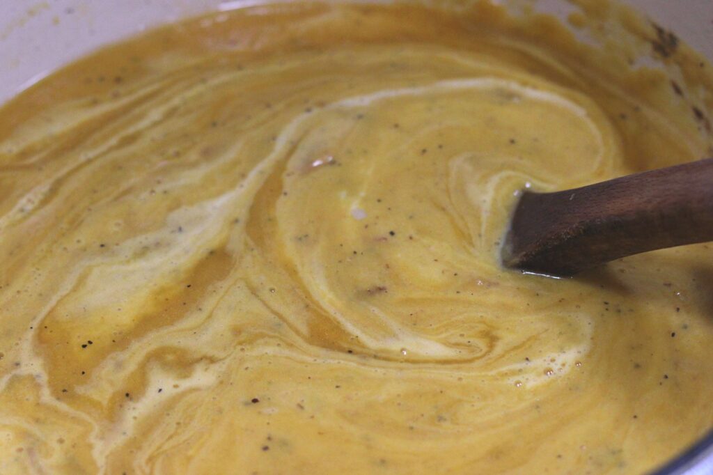 mixing fresh cream into butternut squash soup