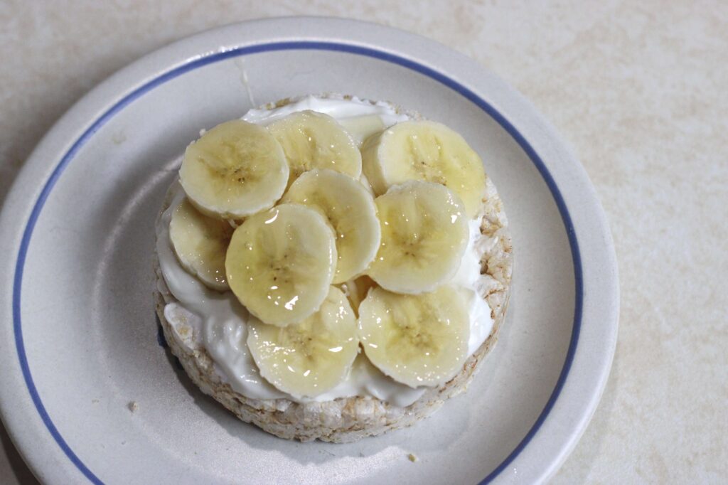 healthy snack of rice cake, plain greek yogurt and banana