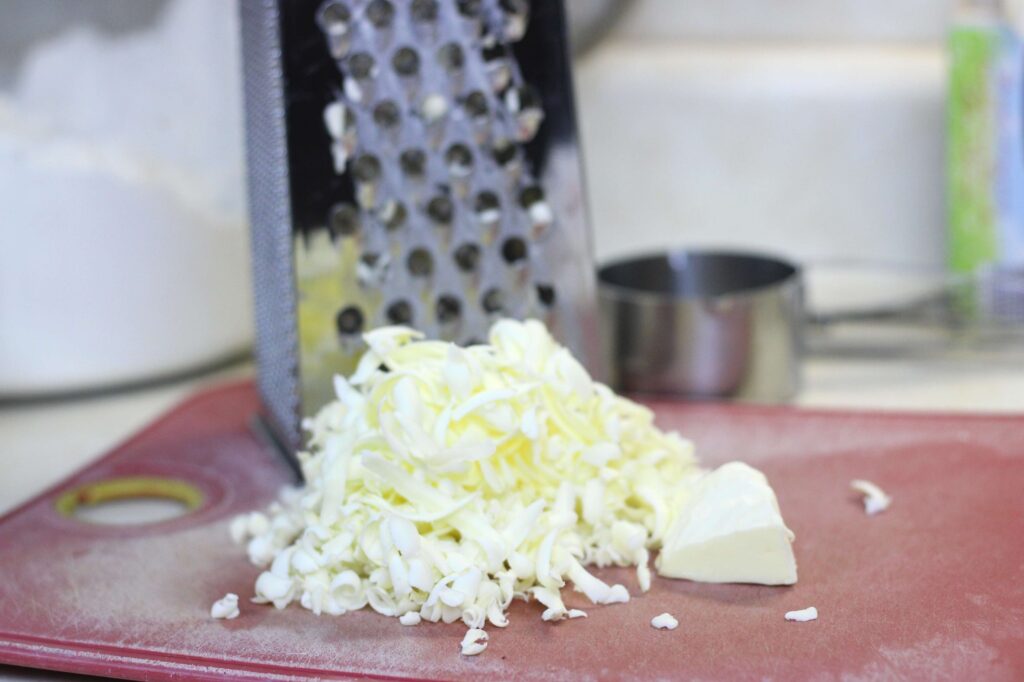 shredded butter on red cutting board