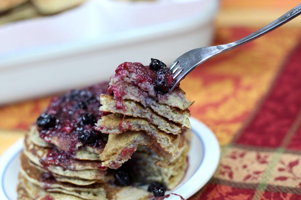 fork full of sourdough pancakes with berry syrup