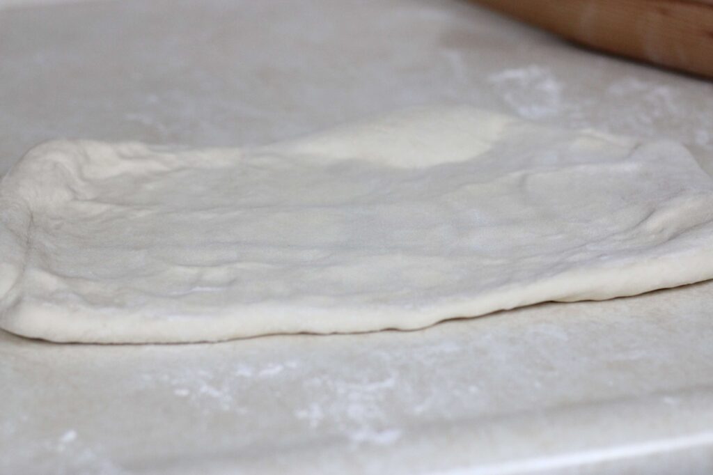 flattened sourdough pastry roll ready for second fold 