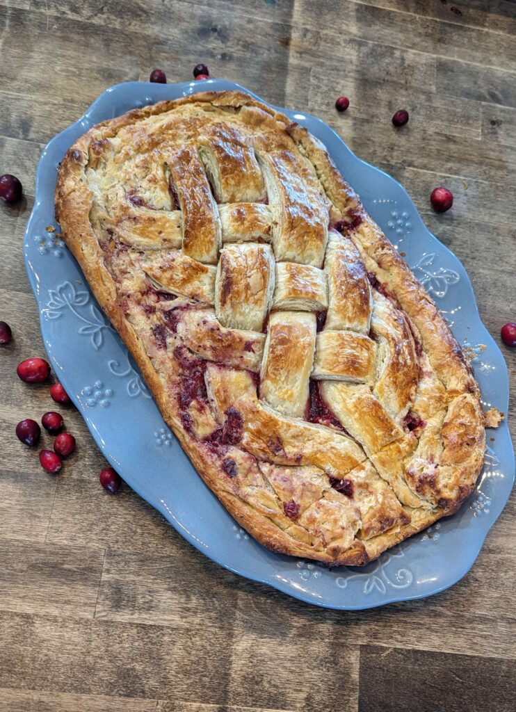 cranberry cream cheese danish on a blue platter made with sourdough pastry dough