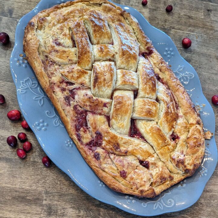 cranberry cream cheese danish on a blue platter made with sourdough pastry dough