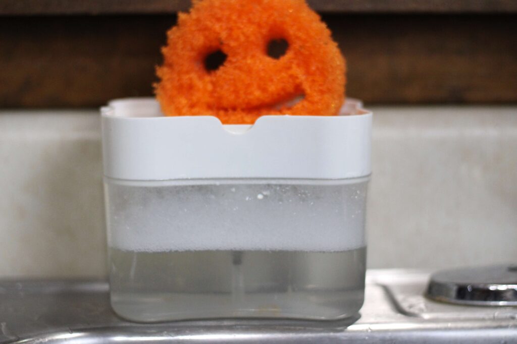 orange scrub daddy sponge sitting on dish soap container