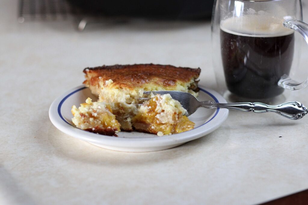 Slice of sourdough dump cake with a side of black coffee 