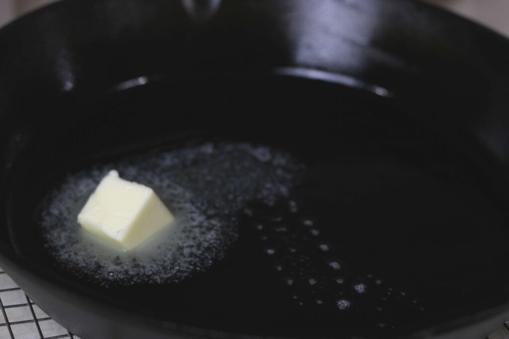 butter melting in preheated cast iron skillet