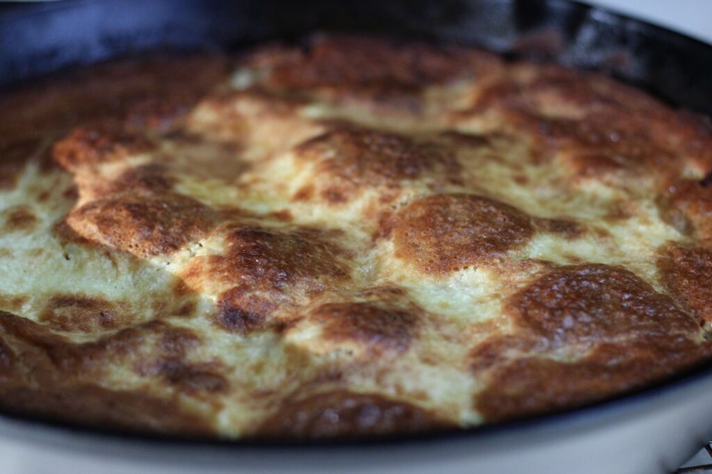 freshly baked sourdough dump cake with peaches and cream