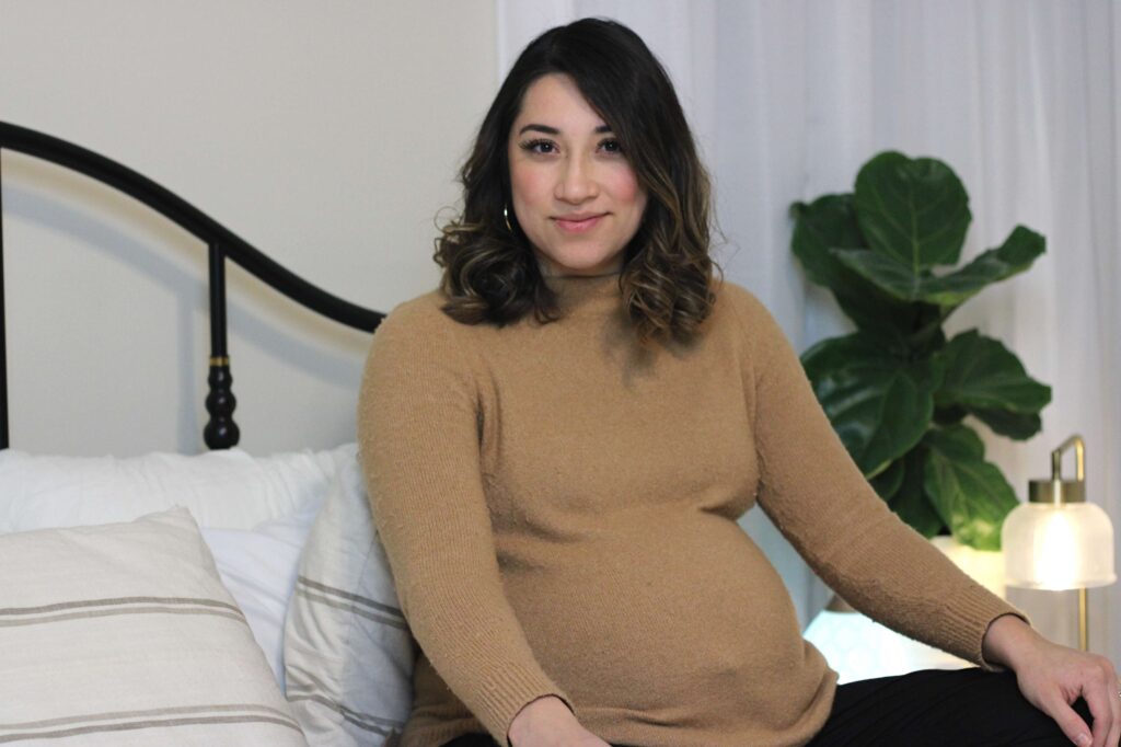 pregnant women sitting in bed smiling 