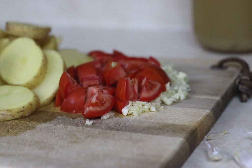 diced tomatoes and minced garlic in cutting board