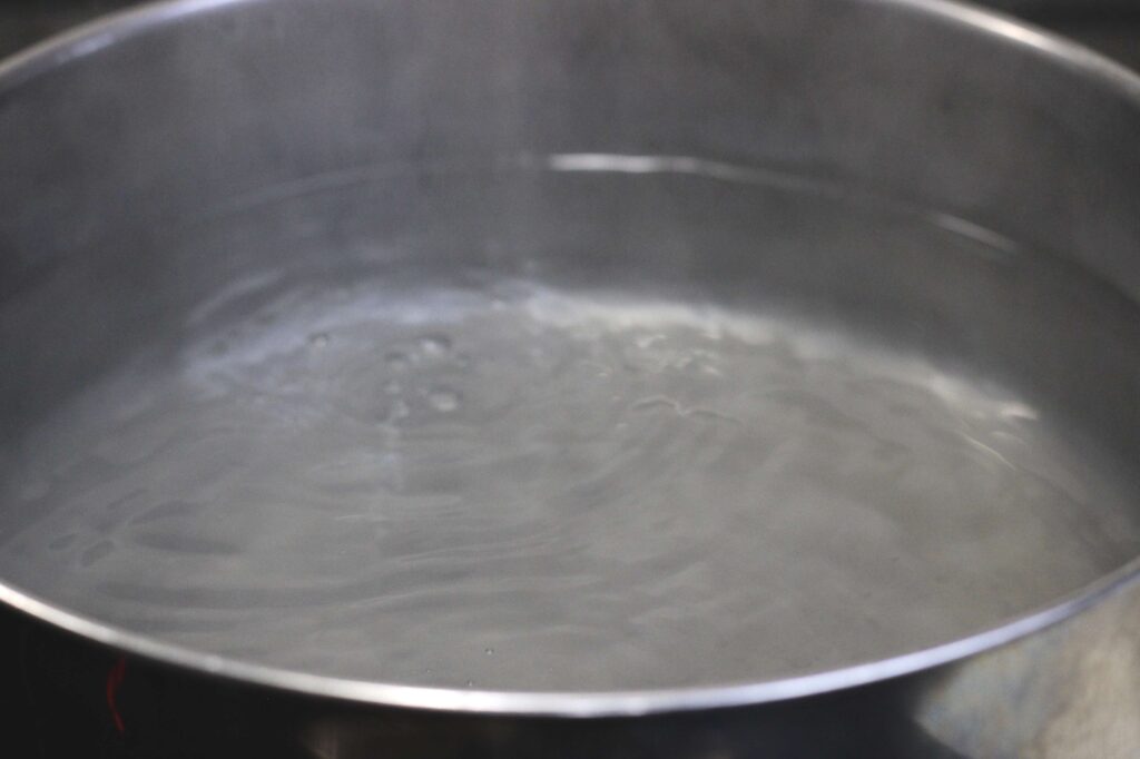 simmering water in stainless steel pot