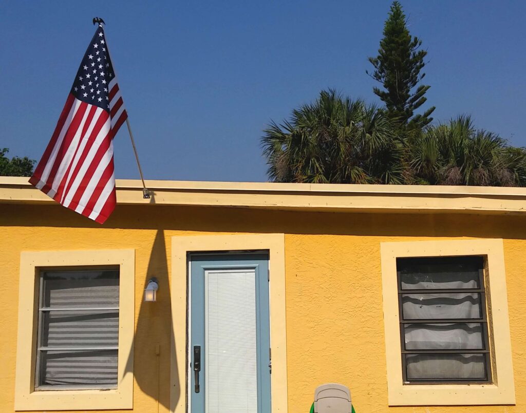 small starter single family home yellow with blue door