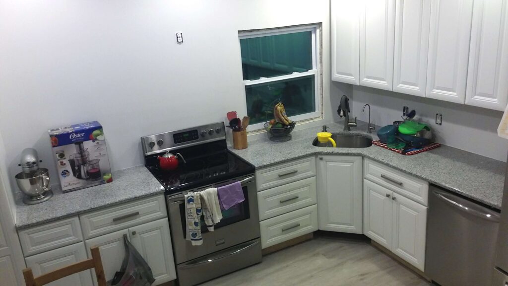 mostly remodeled kitchen with white counters and stainless steel appliances