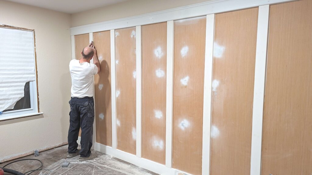 man installing wall panneling