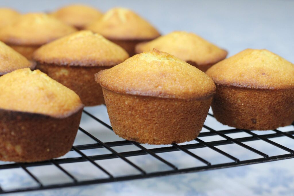 cornbread muffins cooling on black wire rack