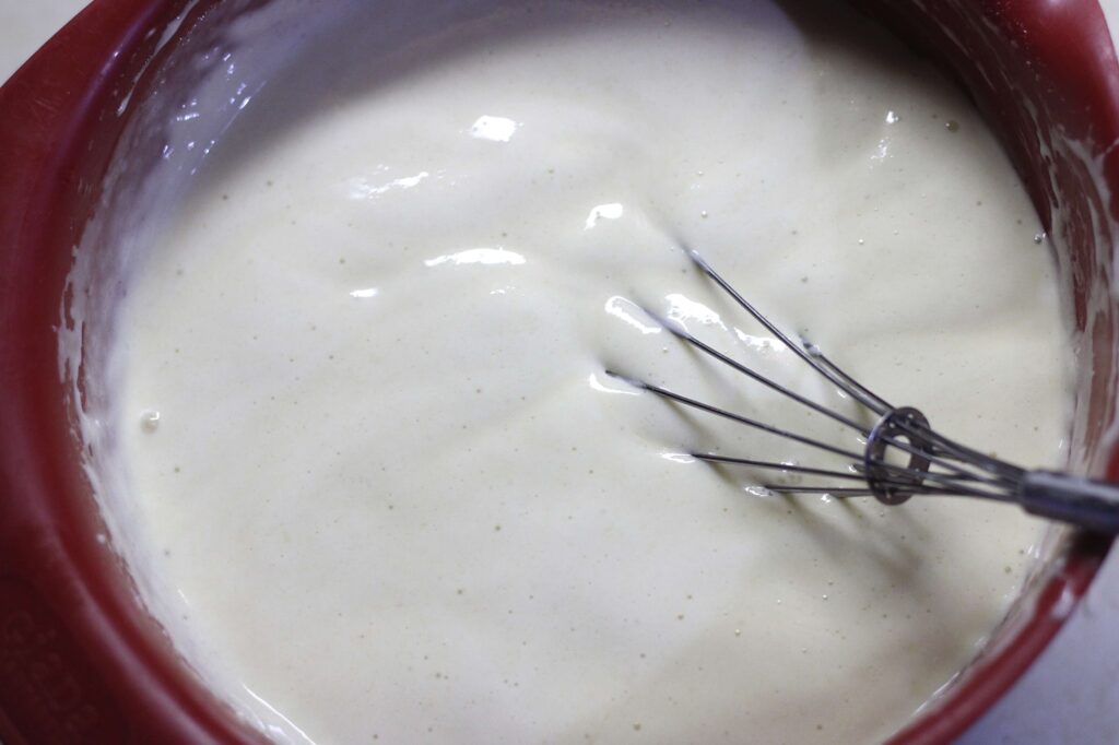 sourdough waffle batter in bowl and whisk