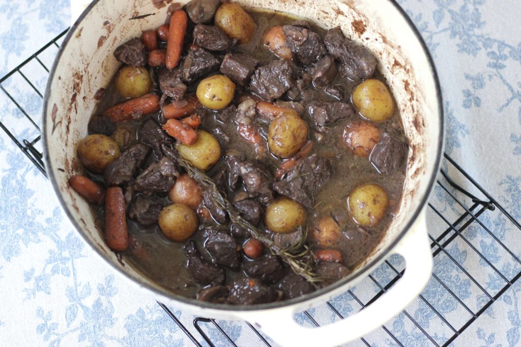 dutch oven with french beef stew, meat, potatoes, carrots 