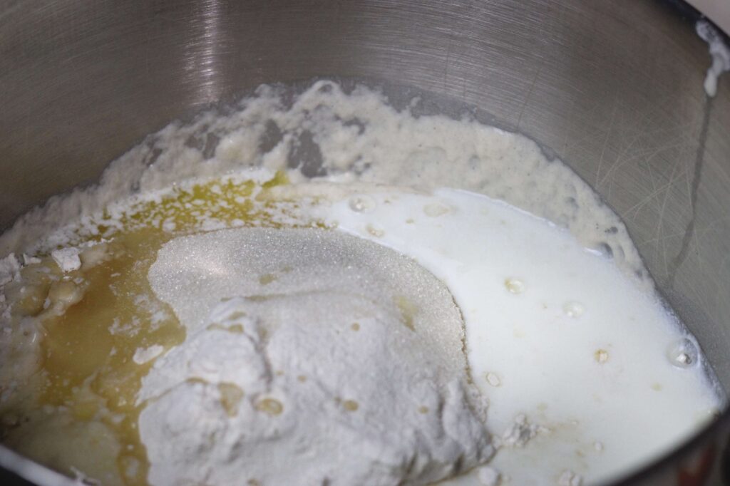 sugar, flour, melted butter, milk, and flour in bowl of stand mixer 